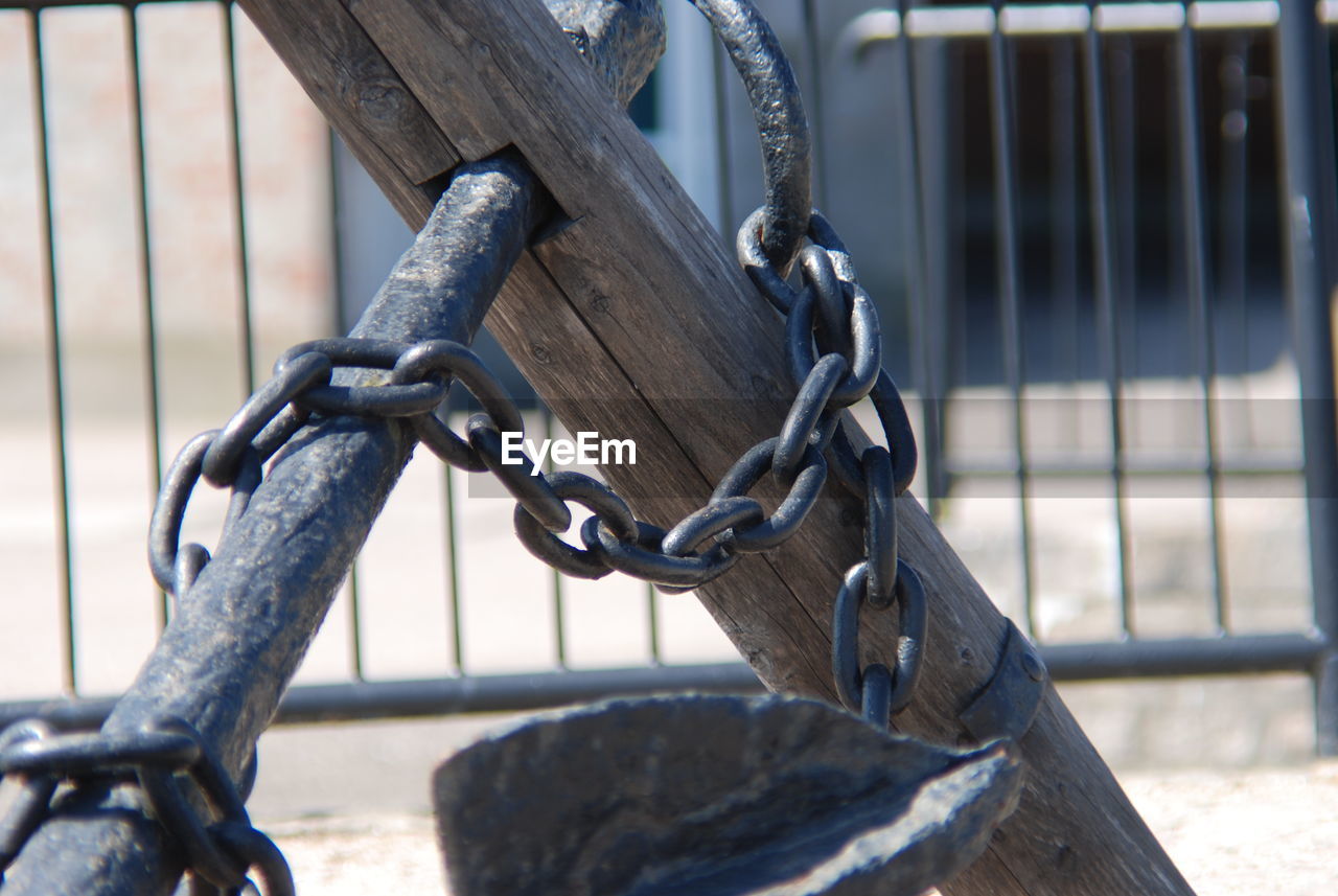 Close-up of chain hanging on wooden rod