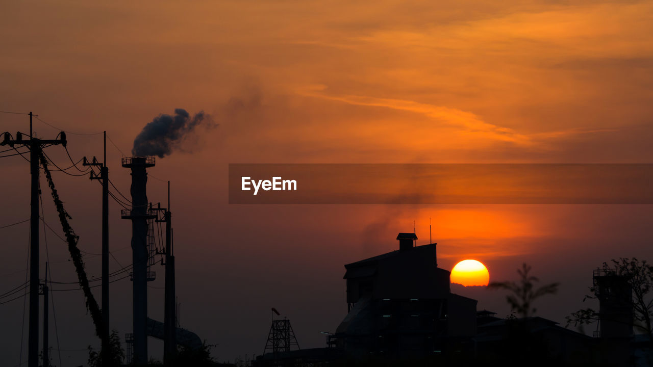 LOW ANGLE VIEW OF SILHOUETTE BUILDINGS AGAINST ORANGE SKY