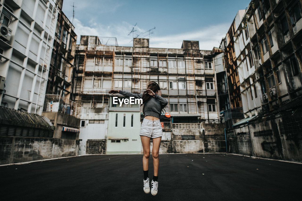 WOMAN STANDING IN CITY