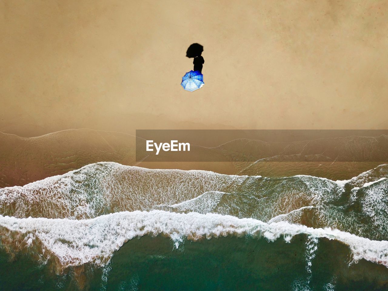 Aerial view of person with umbrella at beach