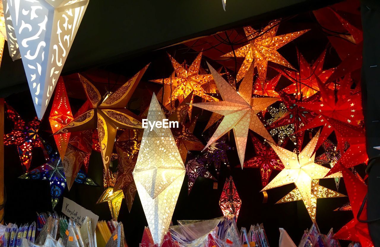 Low angle view of illuminated star shape lanterns at christmas market