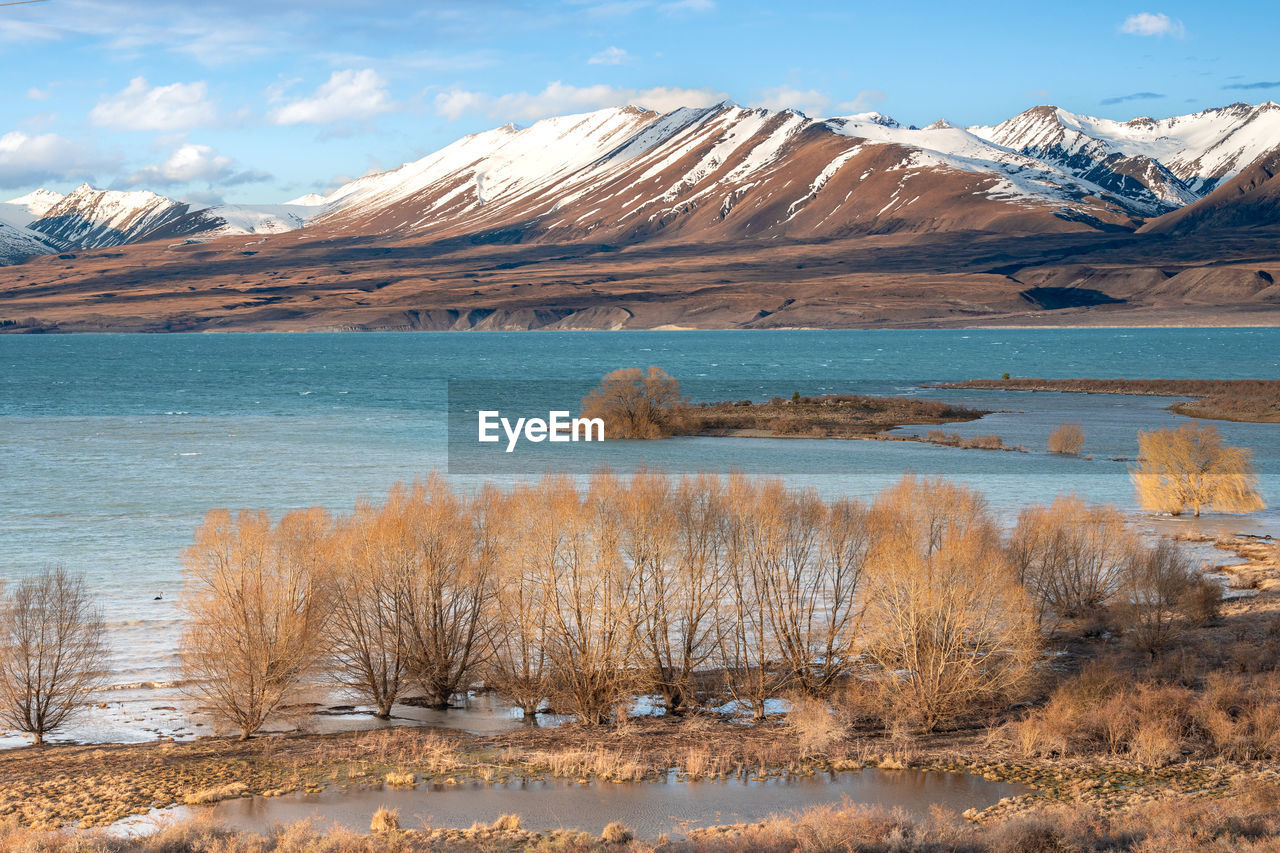 snow, mountain, cold temperature, winter, landscape, wilderness, scenics - nature, environment, beauty in nature, lake, water, snowcapped mountain, nature, sky, mountain range, travel destinations, land, travel, no people, natural environment, plant, tranquil scene, tranquility, plateau, ice, cloud, non-urban scene, tundra, tourism, frozen, outdoors, mountain peak, day, tree, blue, reflection, grass, animal wildlife, polar climate