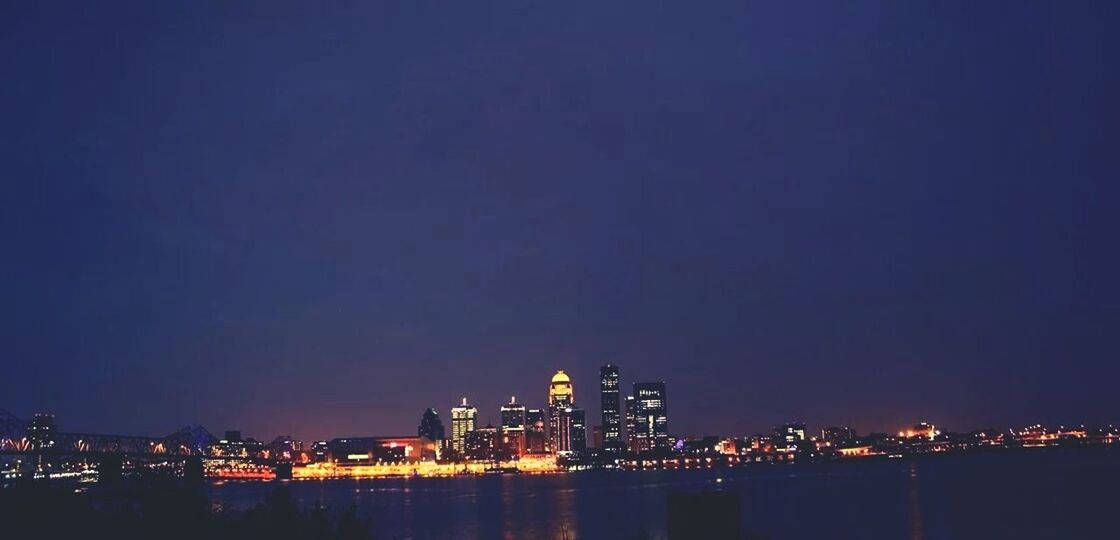 VIEW OF ILLUMINATED CITYSCAPE AT NIGHT