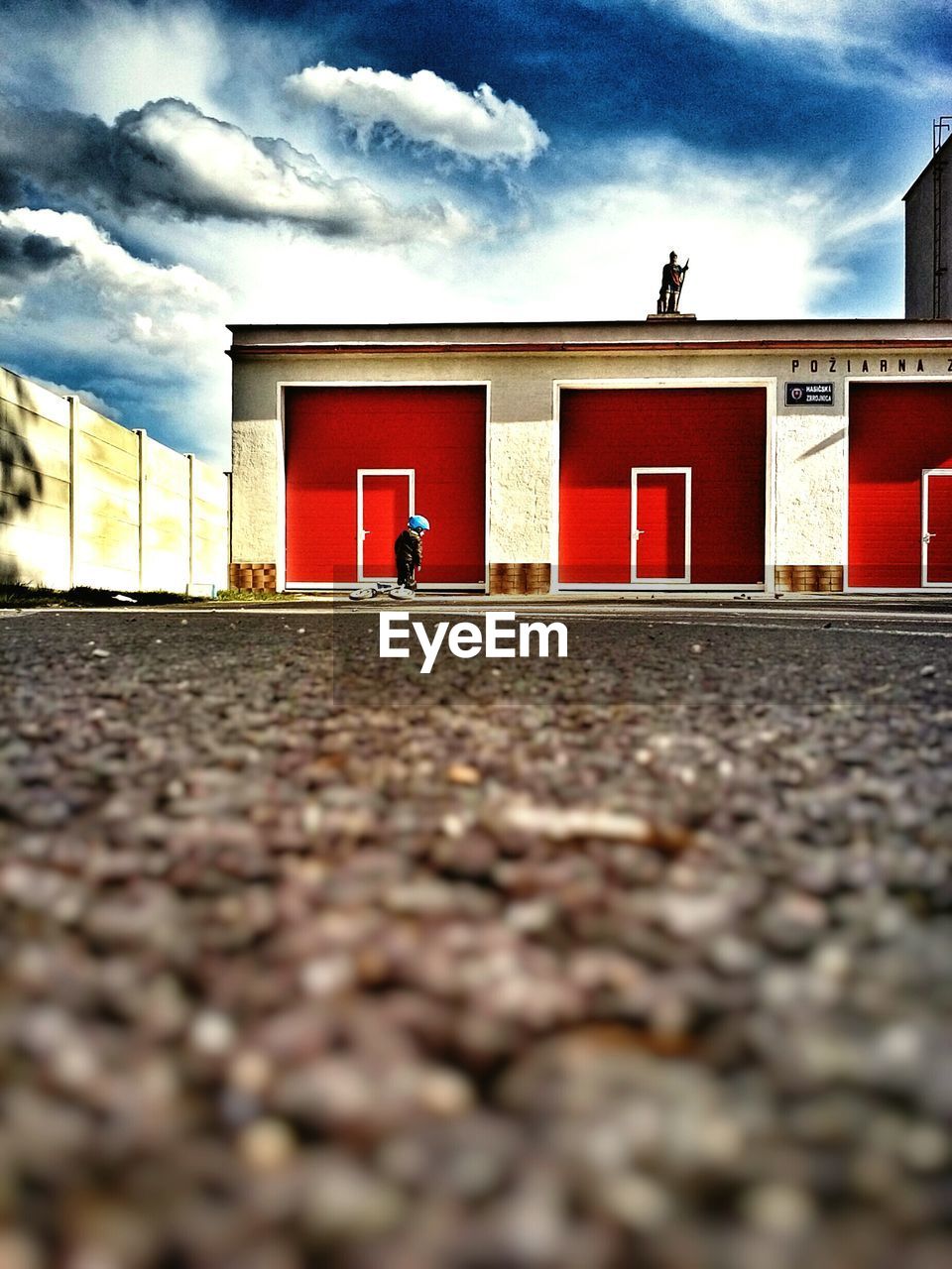 Surface level view of boy with bicycle by garage