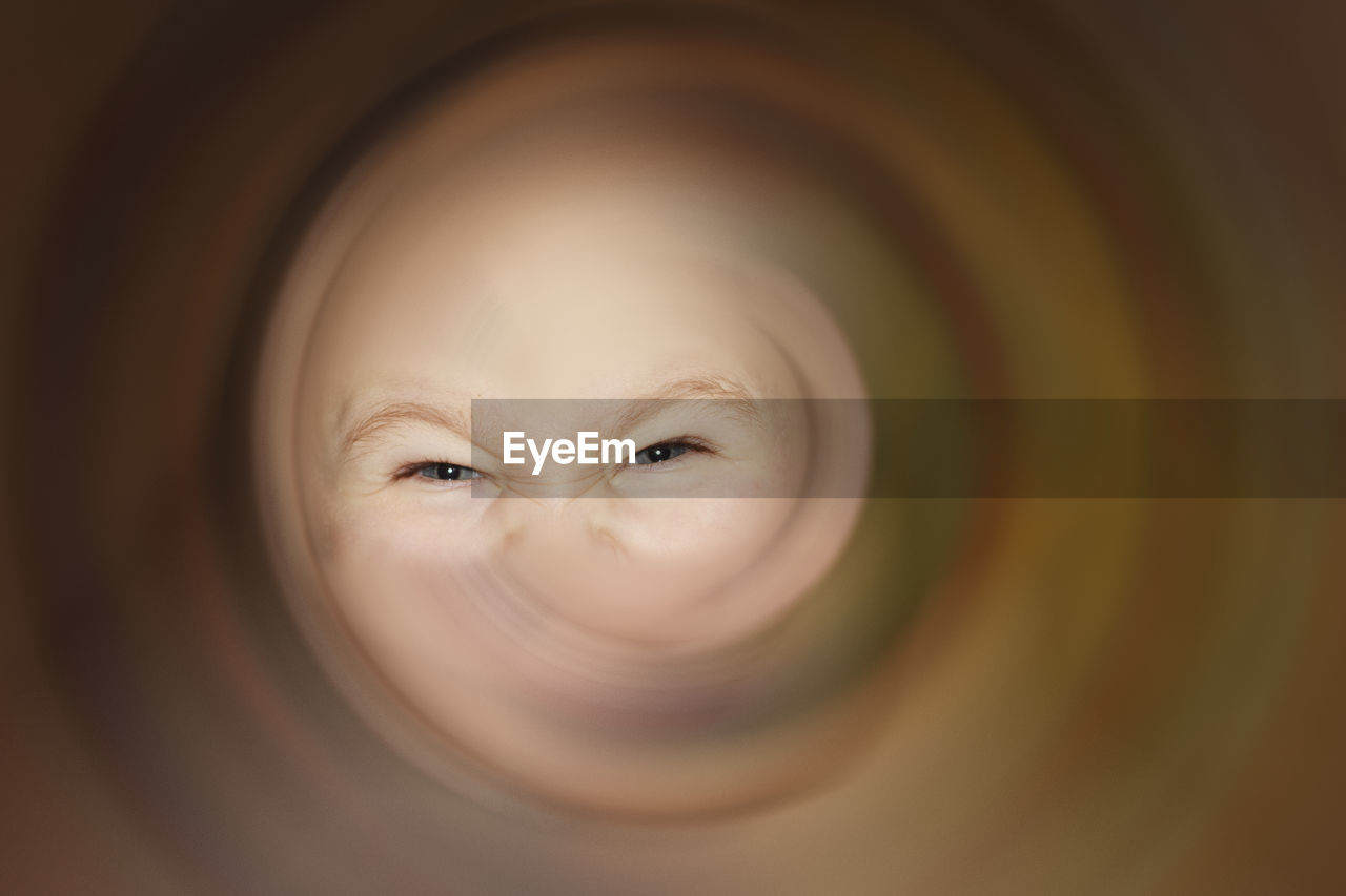 Close-up portrait of boy looking through pipe