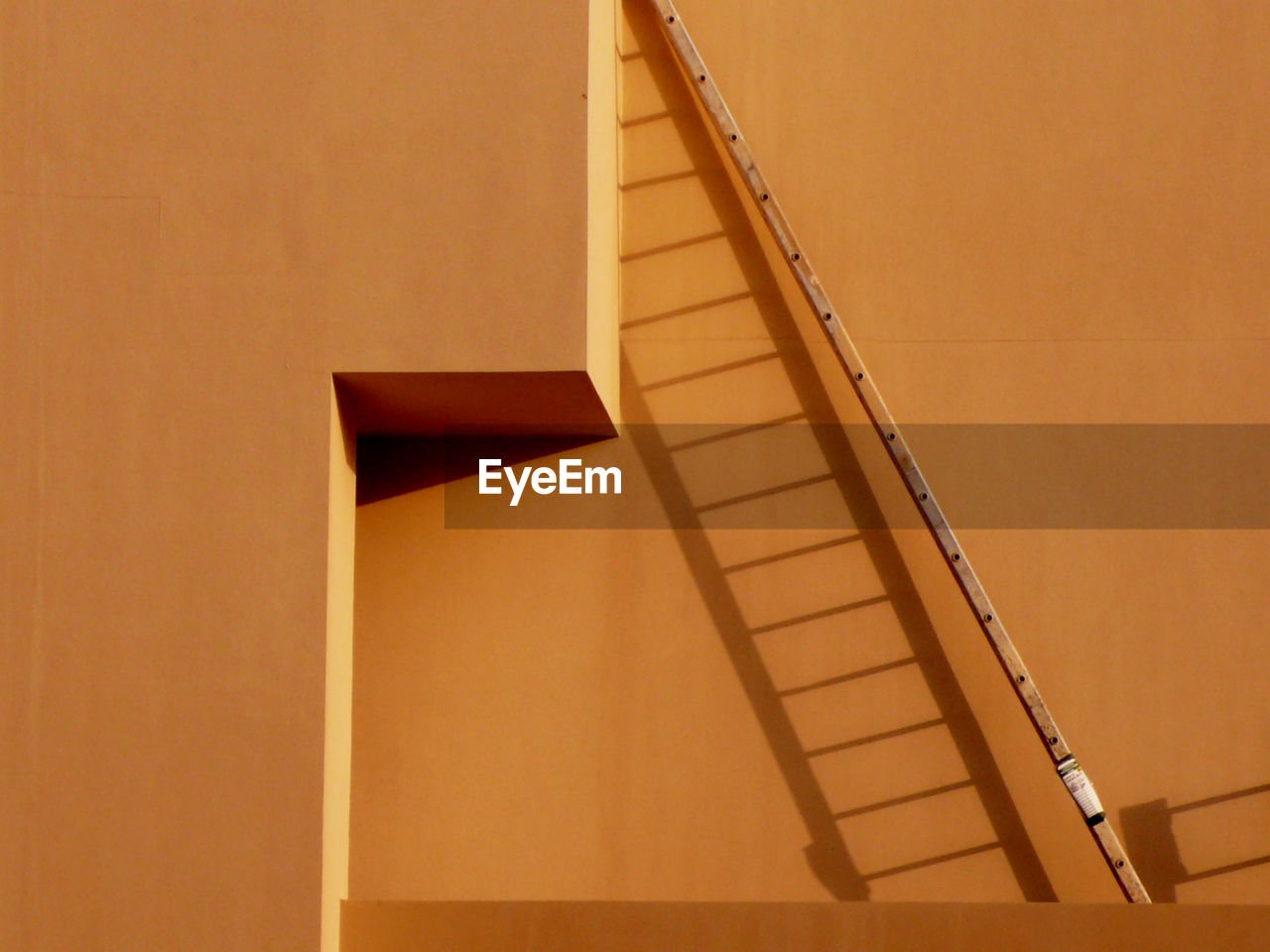 Low angle view of ladder against wall