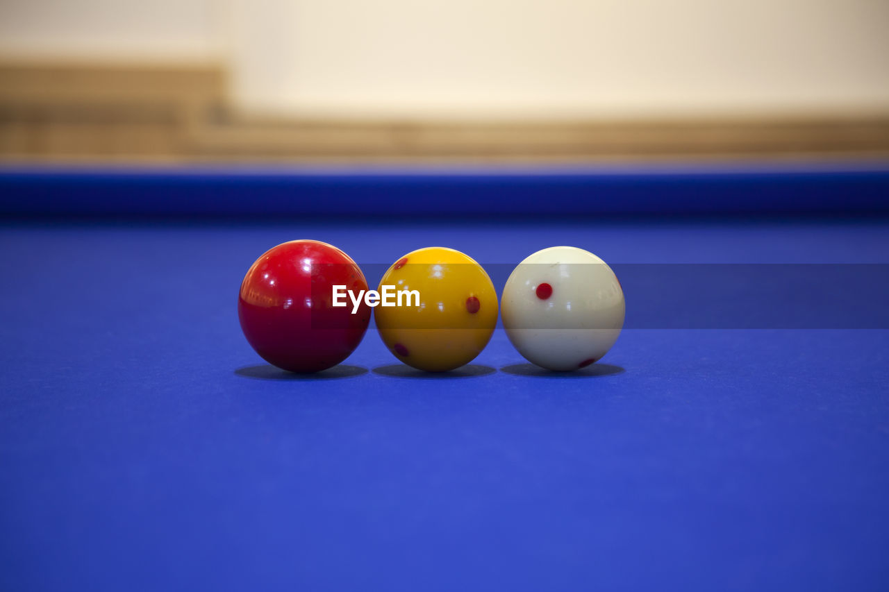 Close-up of cue balls on blue billiards table