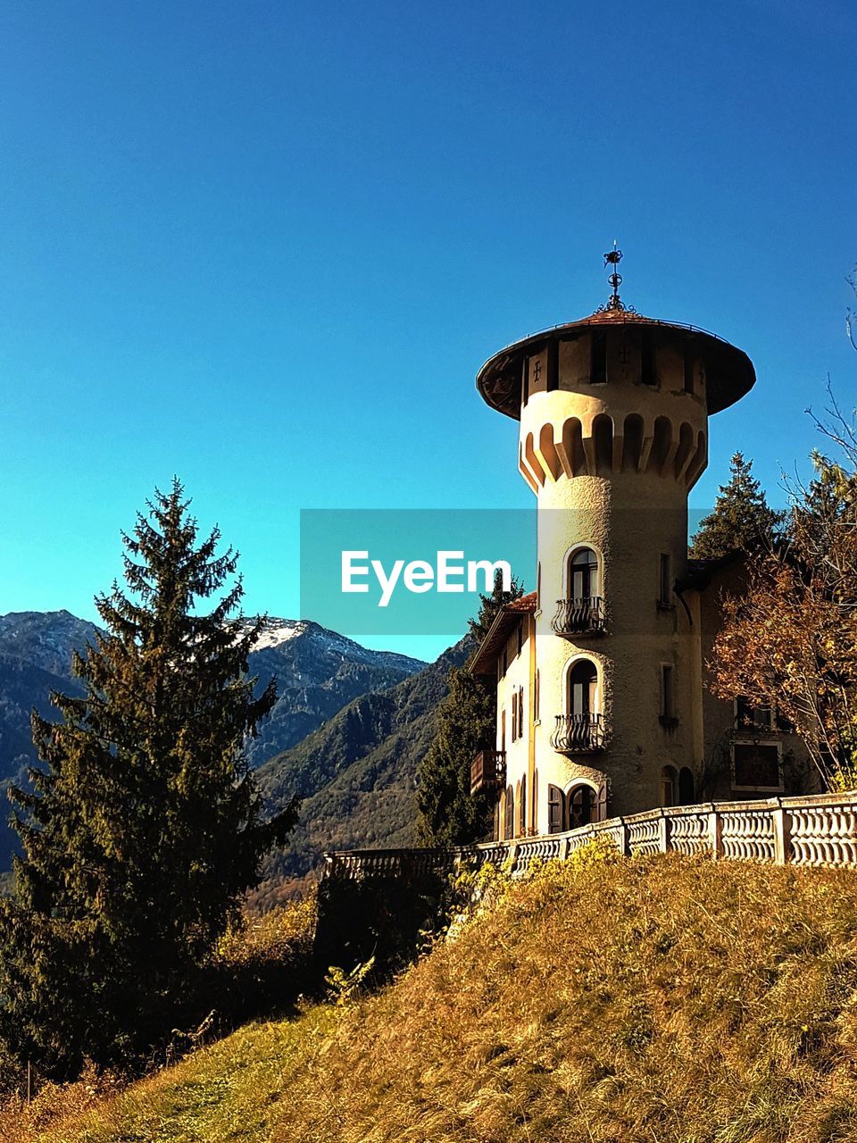 Low angle view of tower on cliff against blue sky