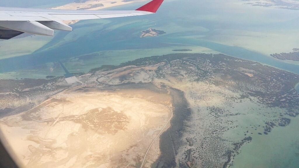 CROPPED IMAGE OF AIRPLANE FLYING OVER SEA