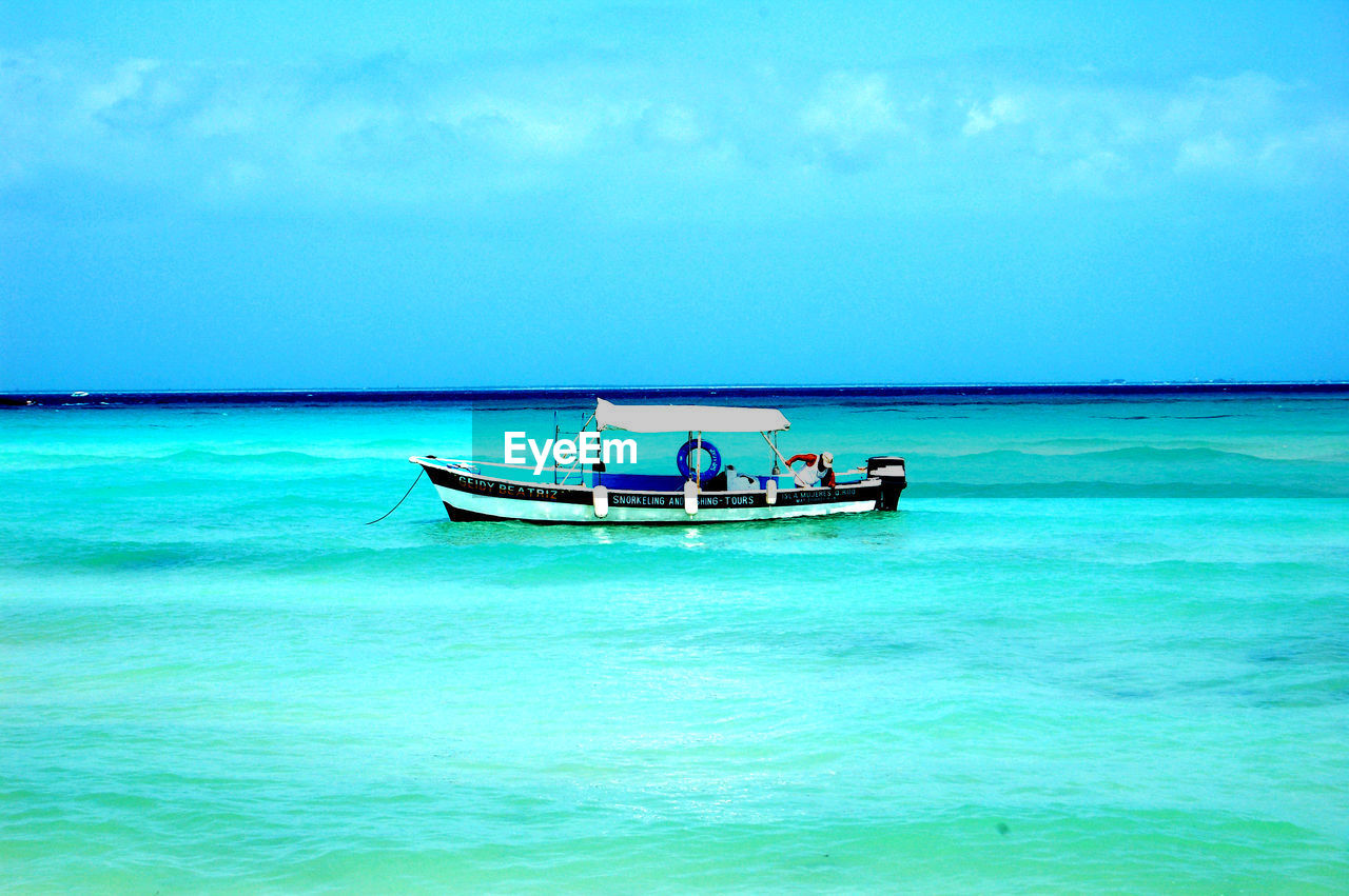 water, sea, nautical vessel, transportation, mode of transportation, sky, beauty in nature, horizon over water, scenics - nature, nature, beach, long-tail boat, travel, horizon, island, blue, land, vehicle, tranquility, turquoise colored, shore, day, tranquil scene, ocean, idyllic, vacation, bay, holiday, boat, travel destinations, tropical climate, trip, lagoon, outdoors, cloud, tourism, two people, non-urban scene, watercraft, ship, waterfront, men, wave