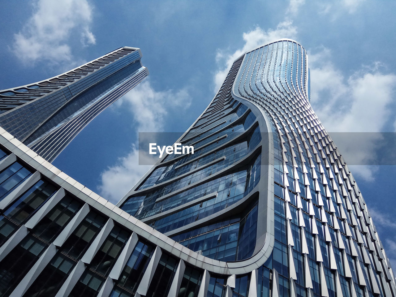 Low angle view of skyscraper against cloudy sky