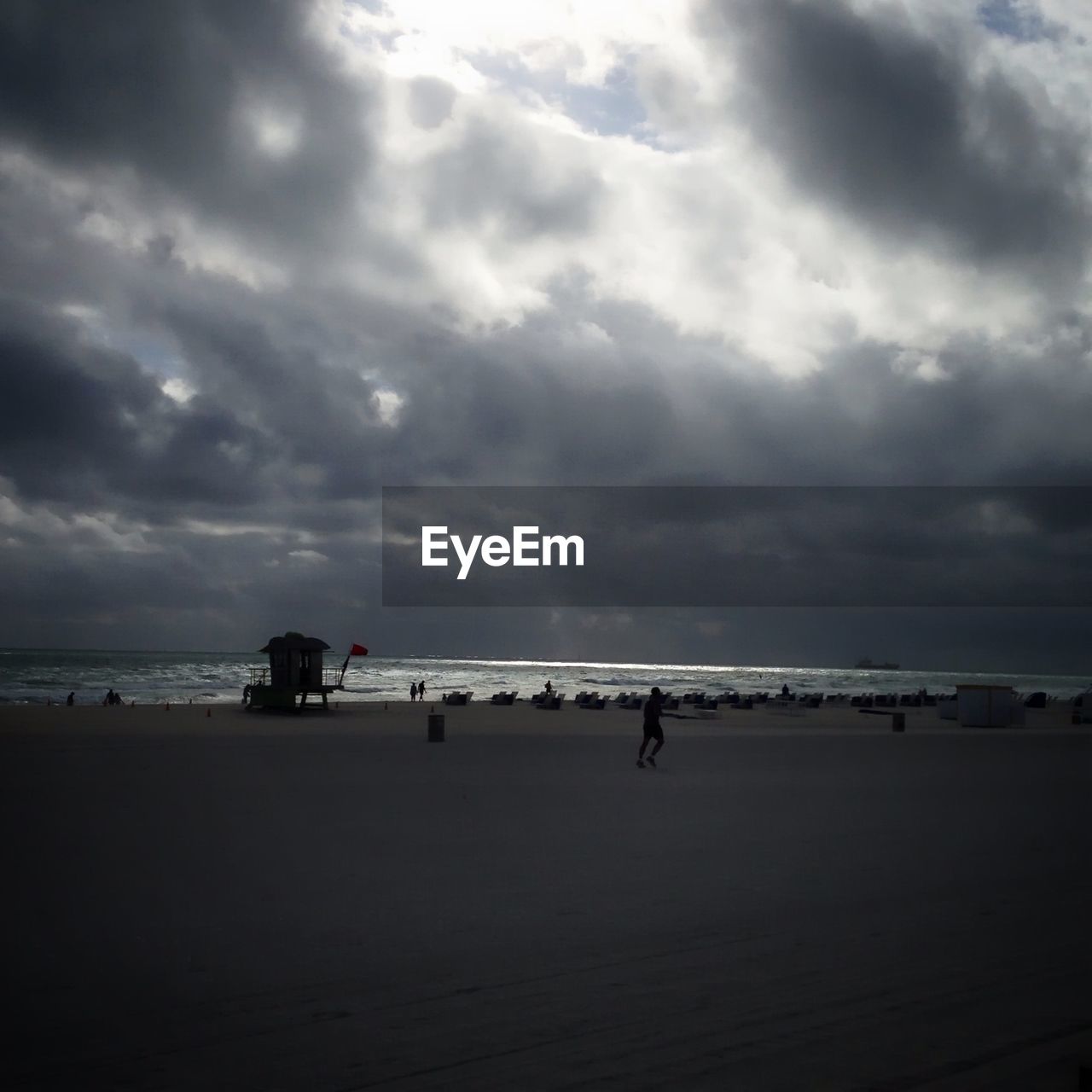 VIEW OF BEACH AGAINST CLOUDY SKY