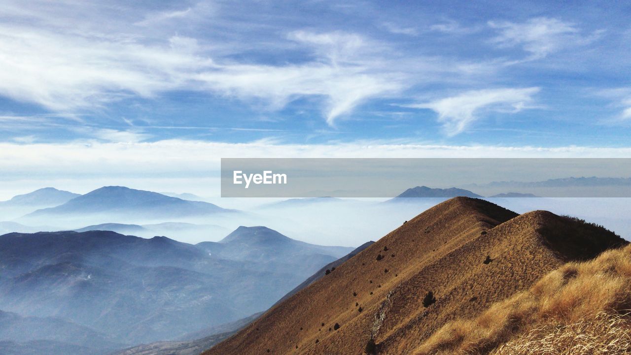 Scenic view of mountains against cloudy sky