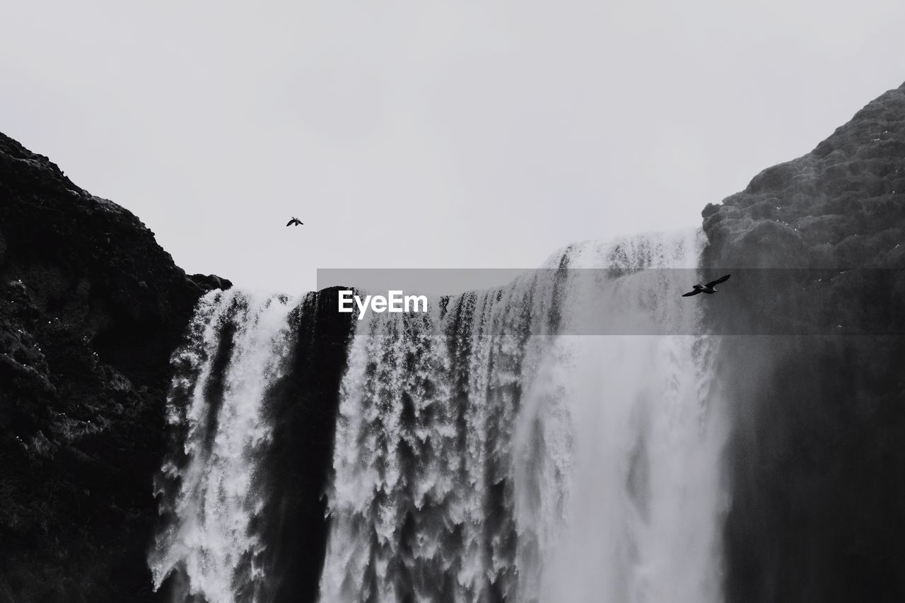 SCENIC VIEW OF WATERFALL AGAINST SKY