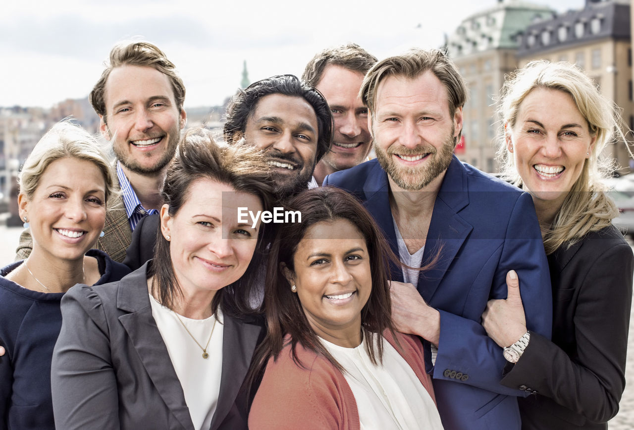 Portrait of happy multi-ethnic business people standing together outdoors