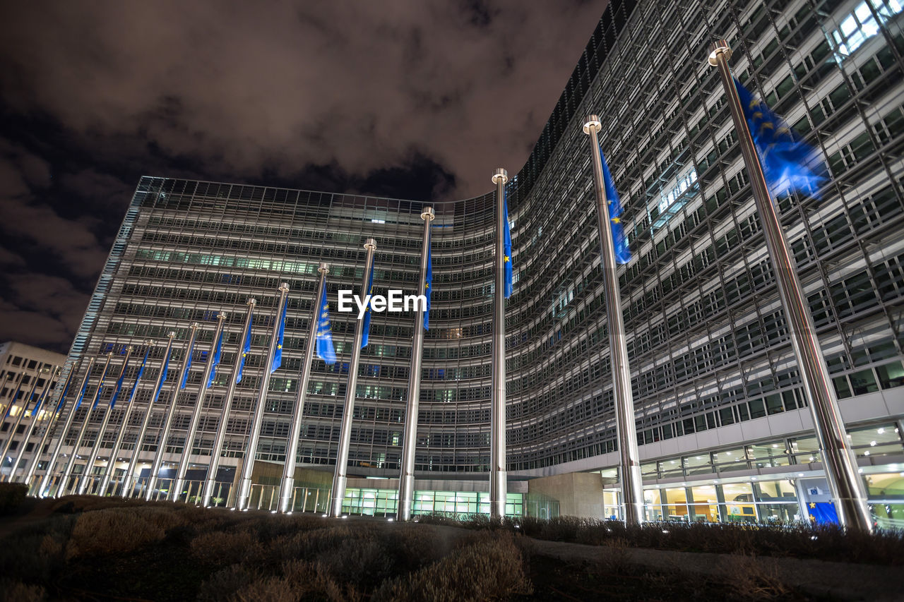 LOW ANGLE VIEW OF ILLUMINATED BUILDING AGAINST CLOUDY SKY