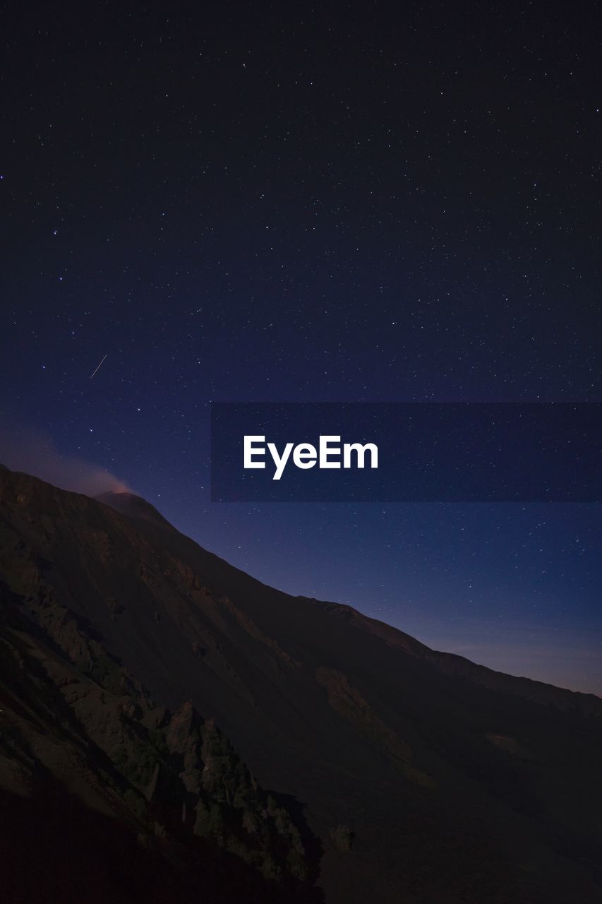 Scenic view of mountains against sky at night