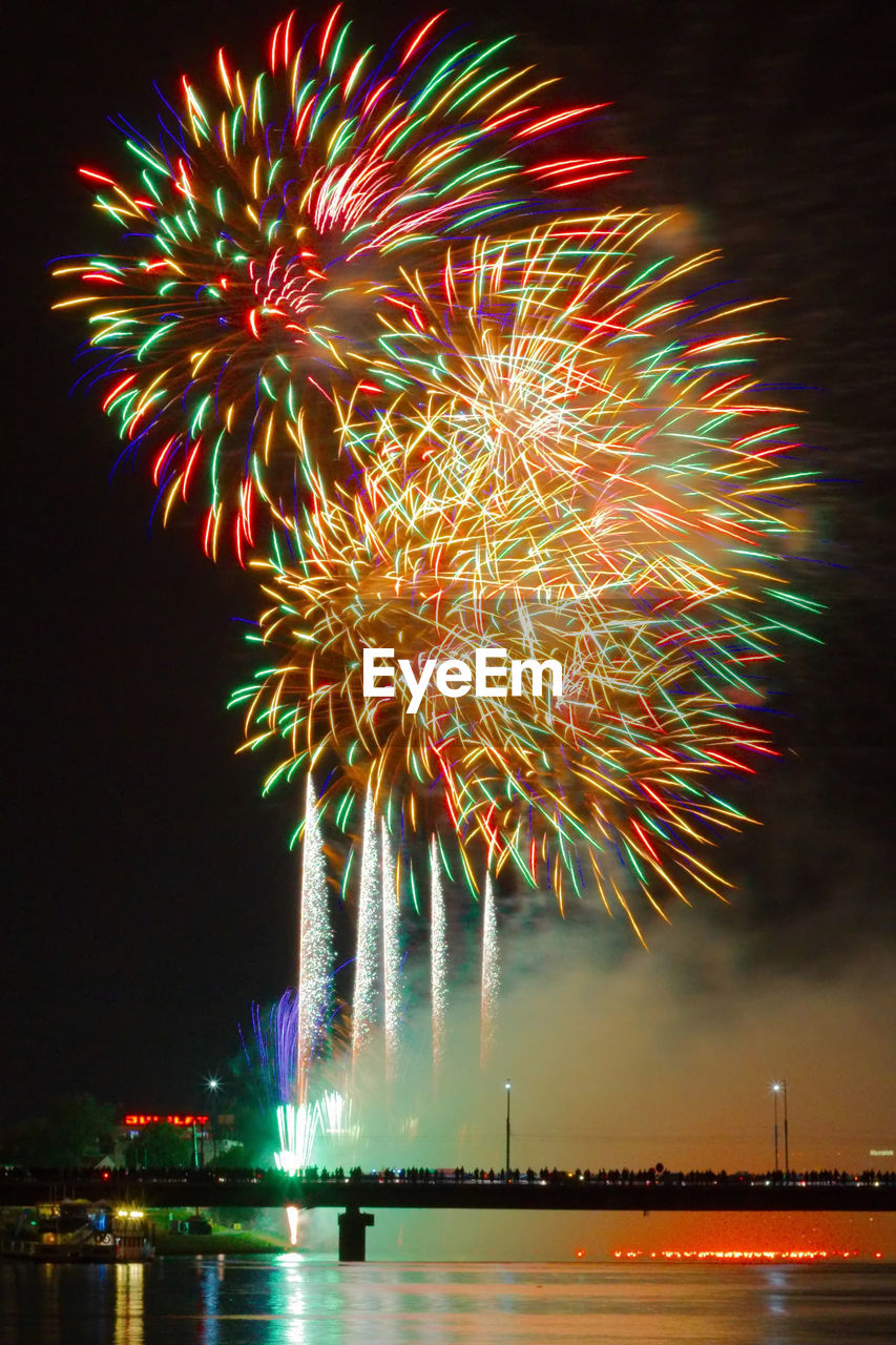 Firework display over river at night