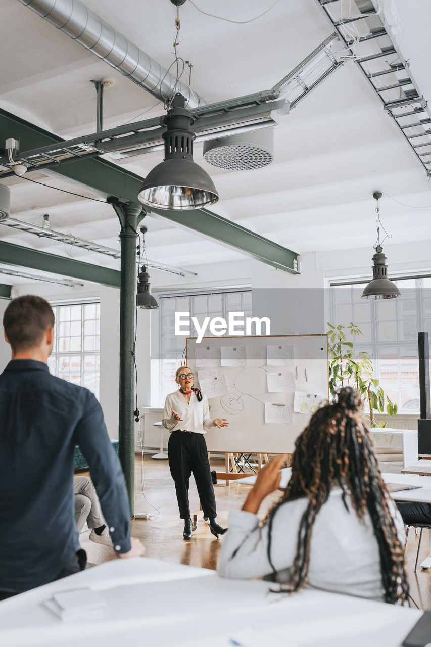 Businesswoman explaining colleagues during meeting at work place