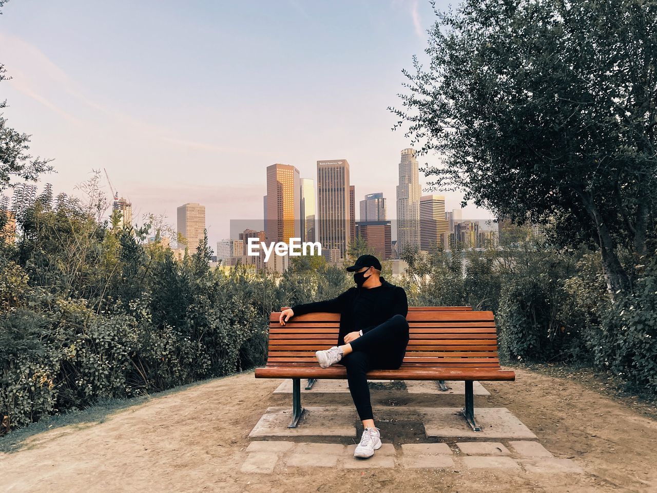 Man sitting on bench in city park