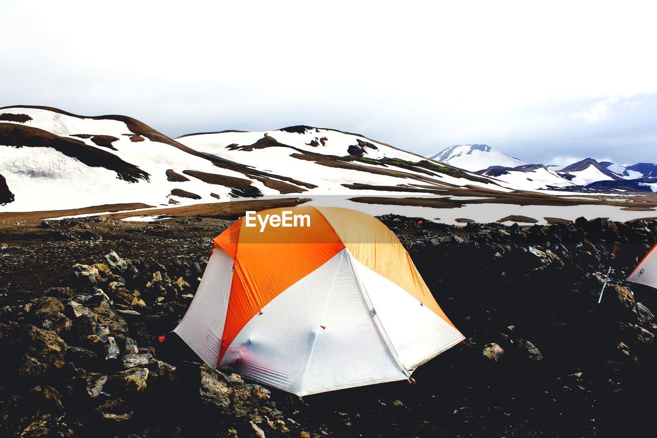 UMBRELLA ON SNOW COVERED MOUNTAIN AGAINST SKY