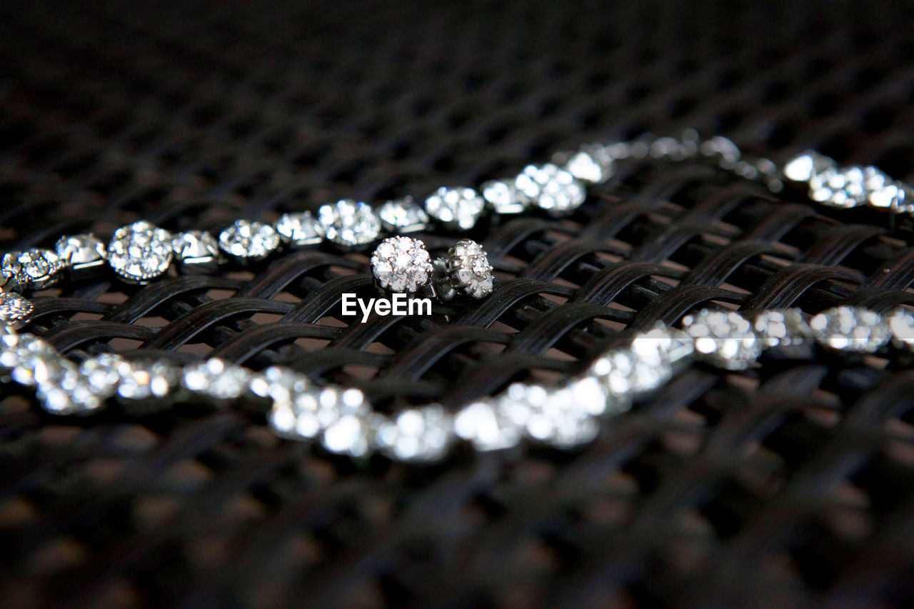 Close-up of diamond necklace and earring on table