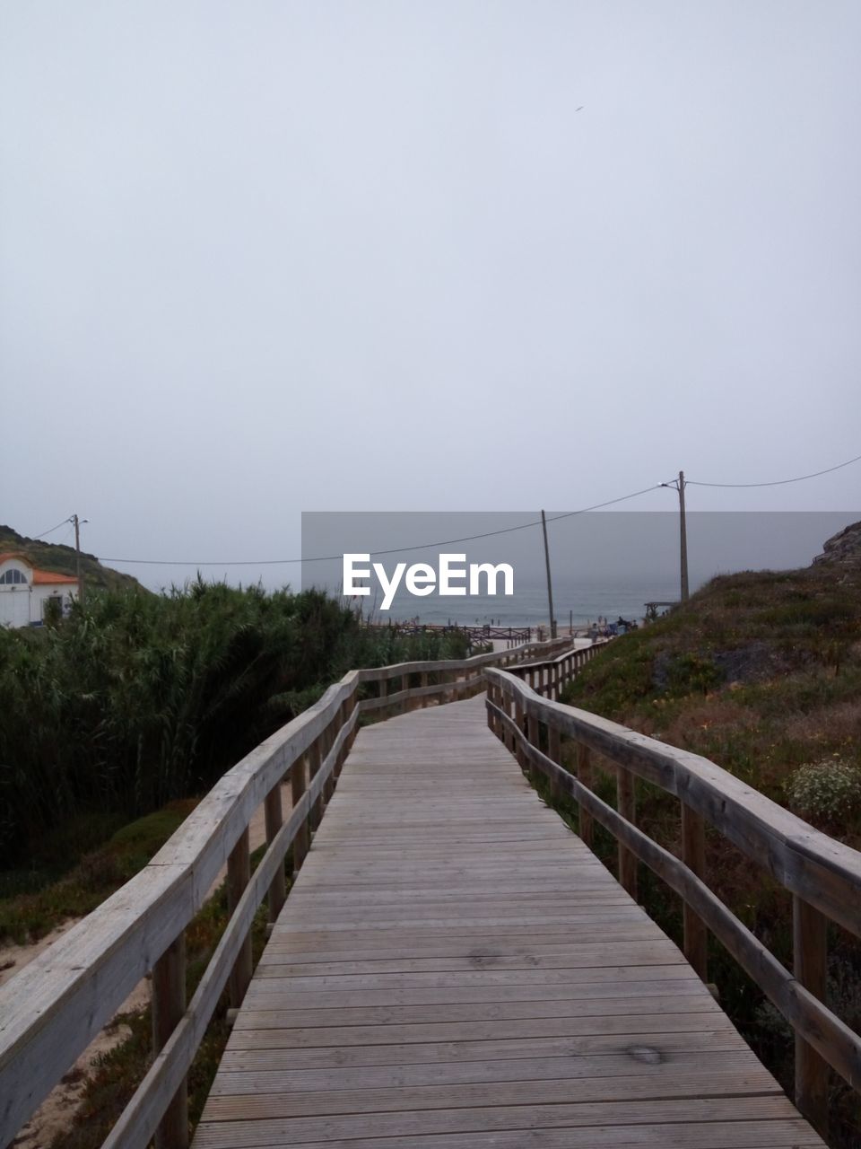 FOOTBRIDGE OVER WATER AGAINST SKY