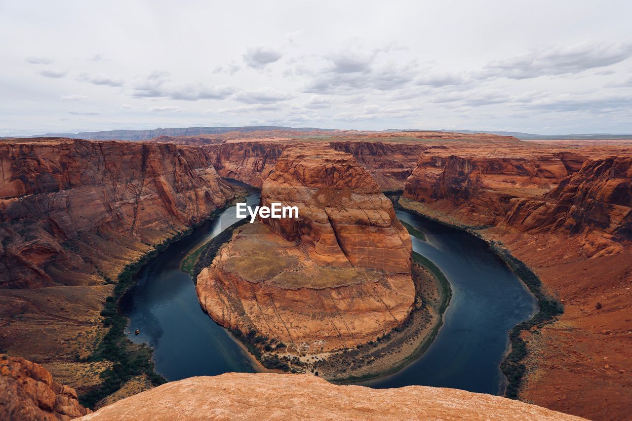 Scenic view of horseshoe bend by river against sky