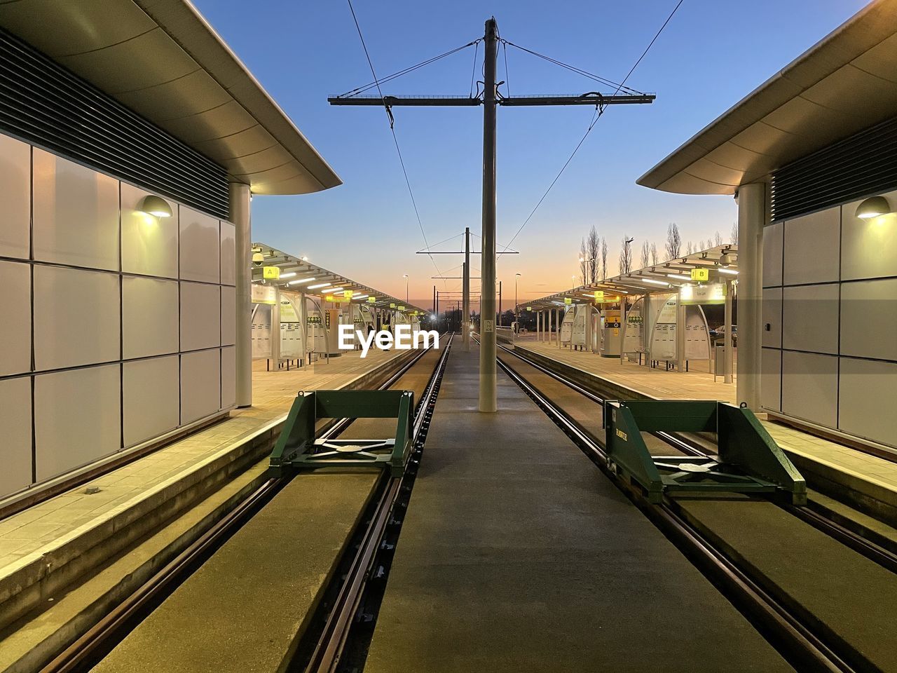 RAILROAD TRACKS BY BUILDINGS AGAINST SKY