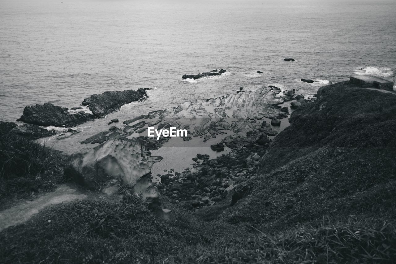 High angle view of rocks in sea against sky