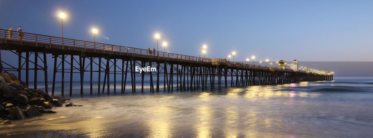 Oceanside pier at dusk. the ocean is calming and night will prevail. reflections of serenity.