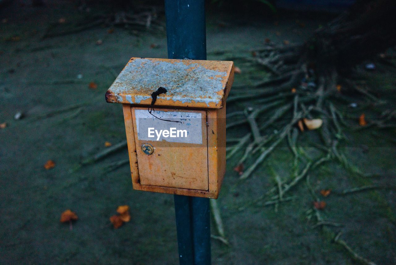 Close-up of rusty letter box on pole