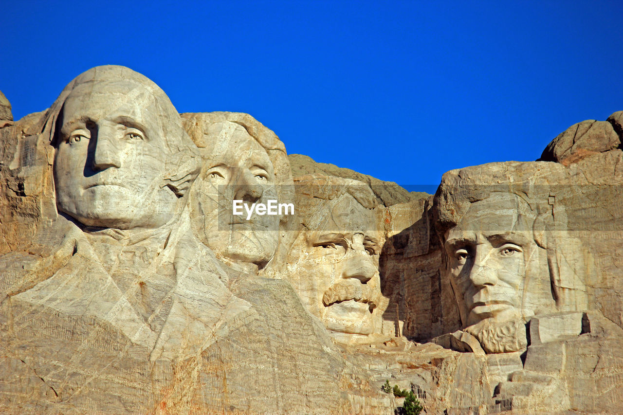 Low angle view of mt rushmore national monument against clear blue sky