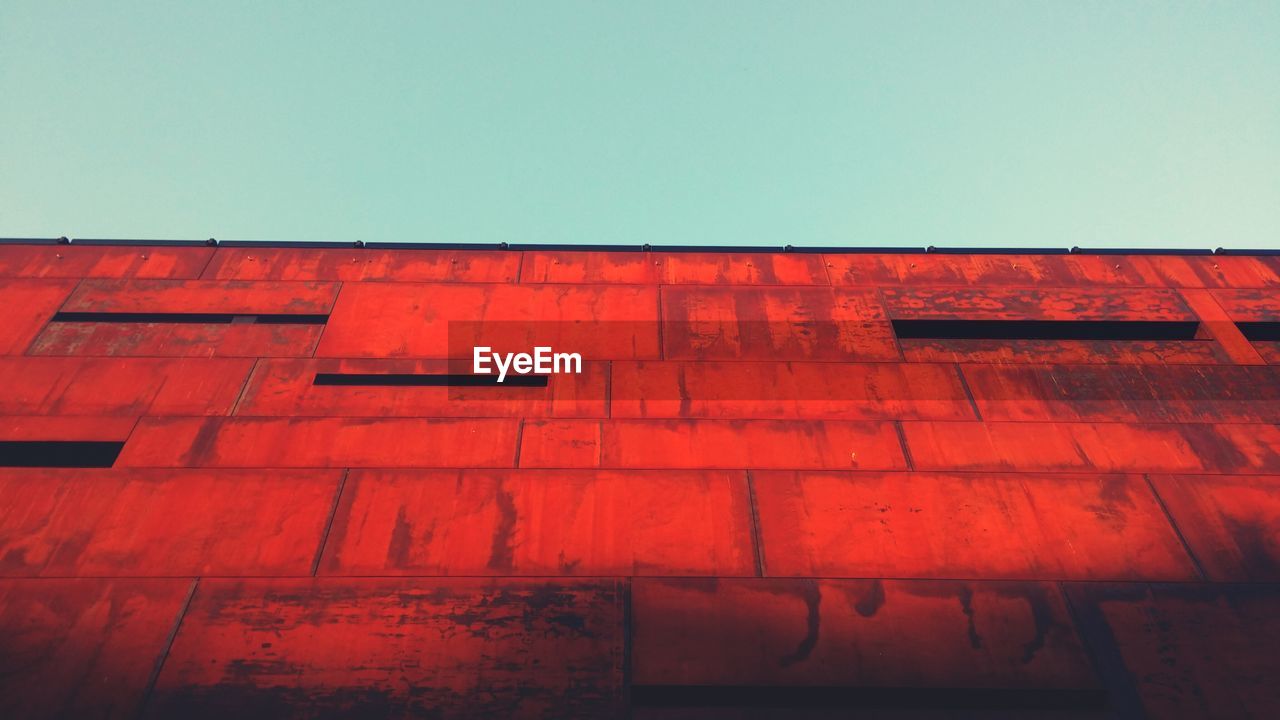 Low angle view of red building against clear sky