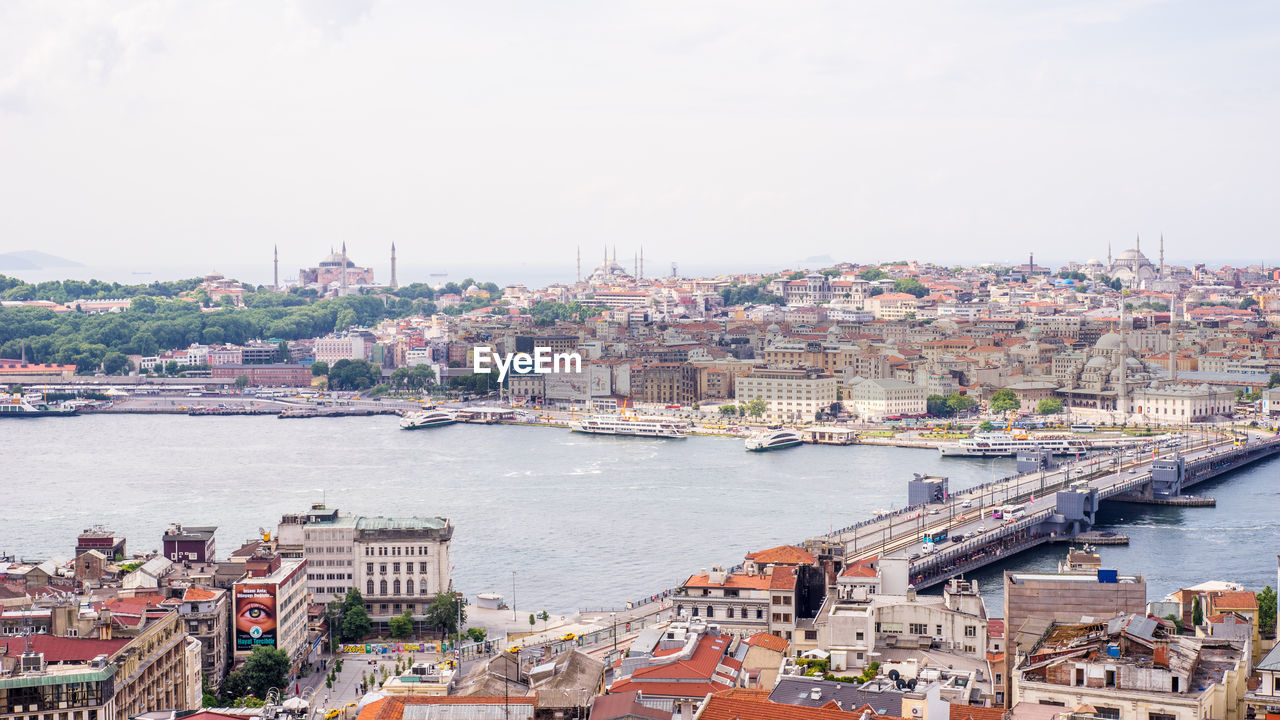 High angle view of cityscape amidst river against sky