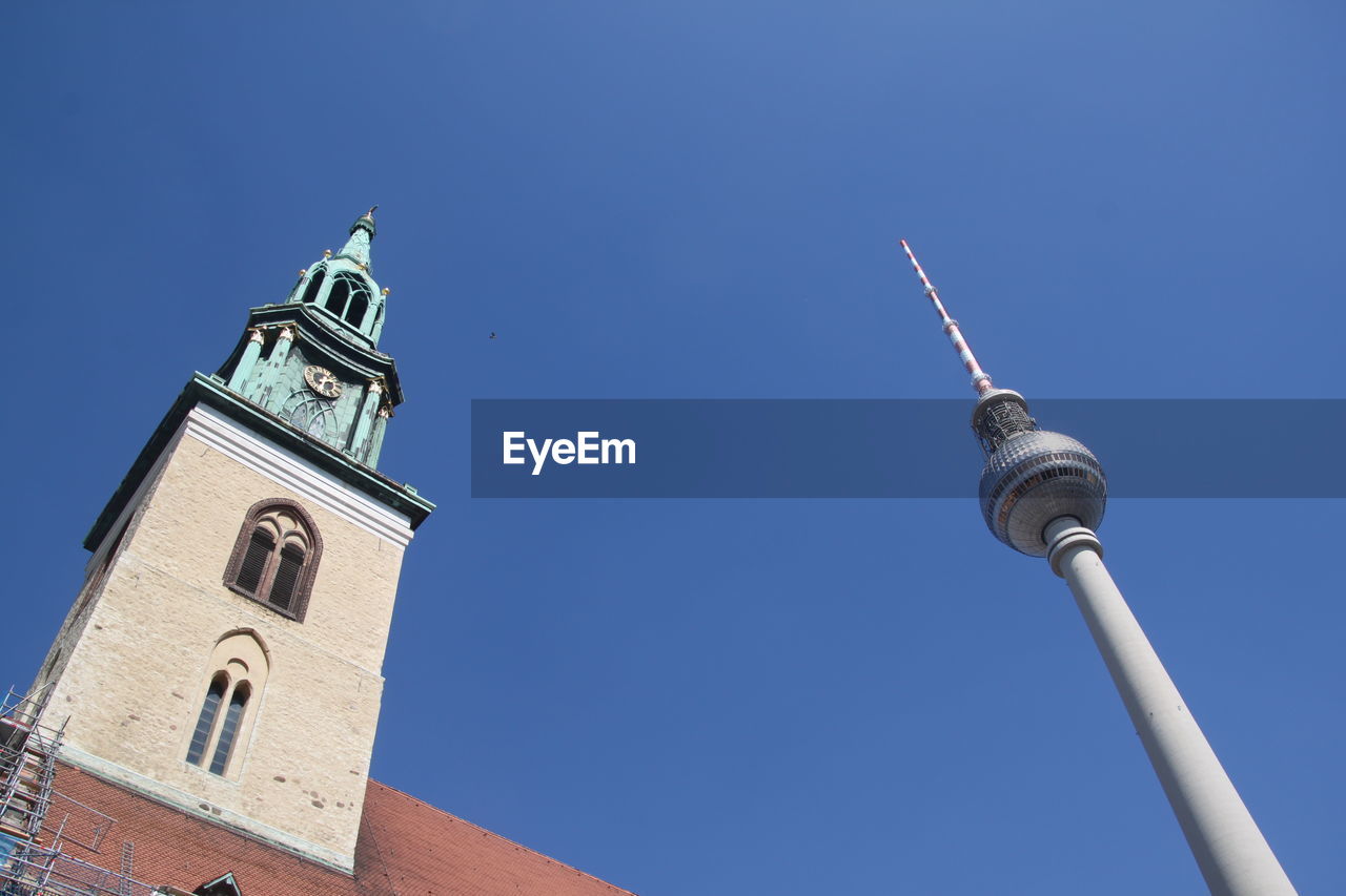Low angle view of tv  tower and church against sky