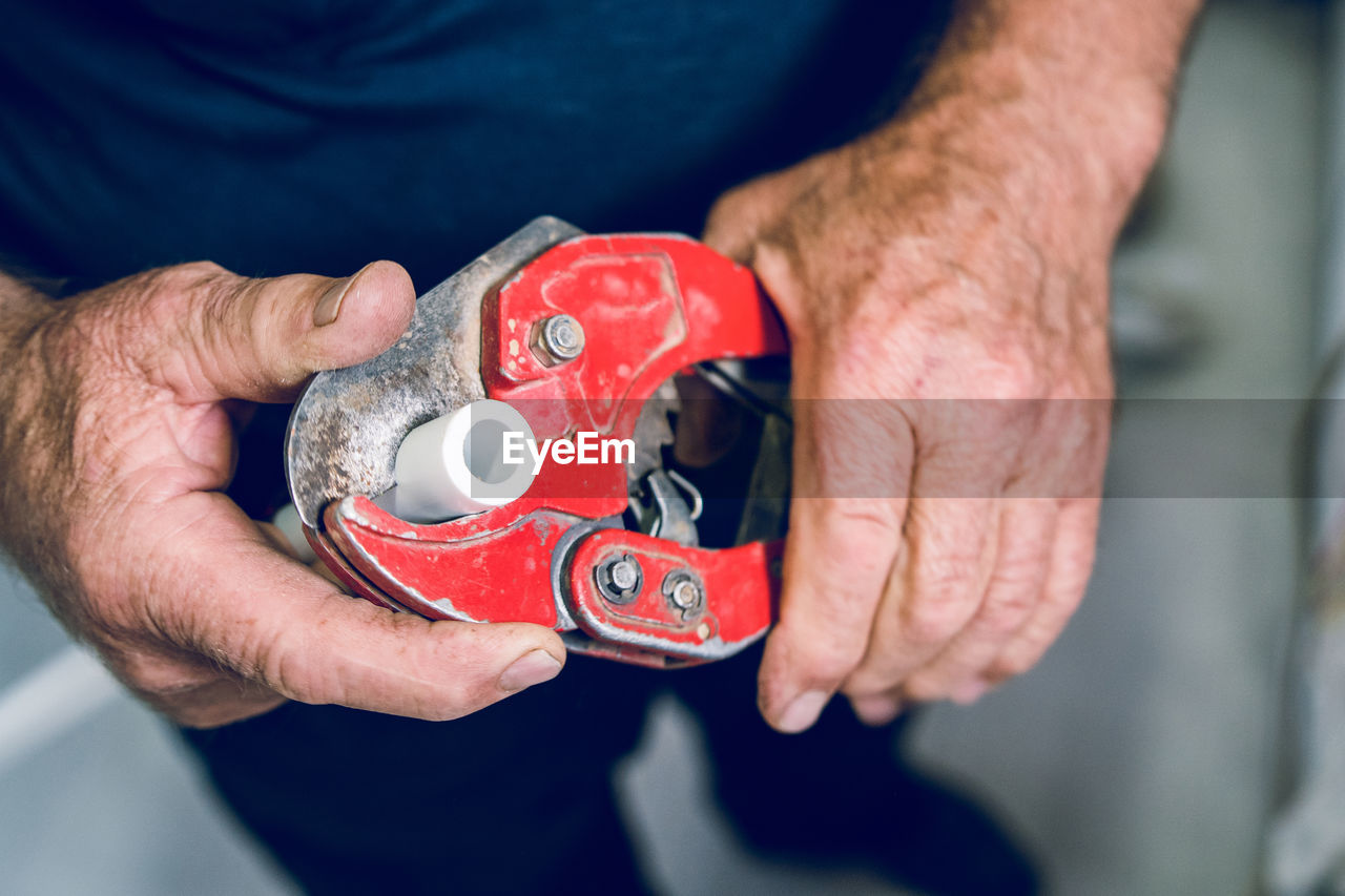 Midsection of man holding work tool