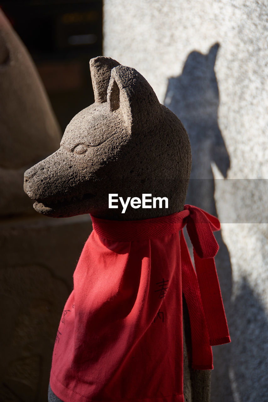 REAR VIEW OF CHILD WITH TOY ON RED SURFACE