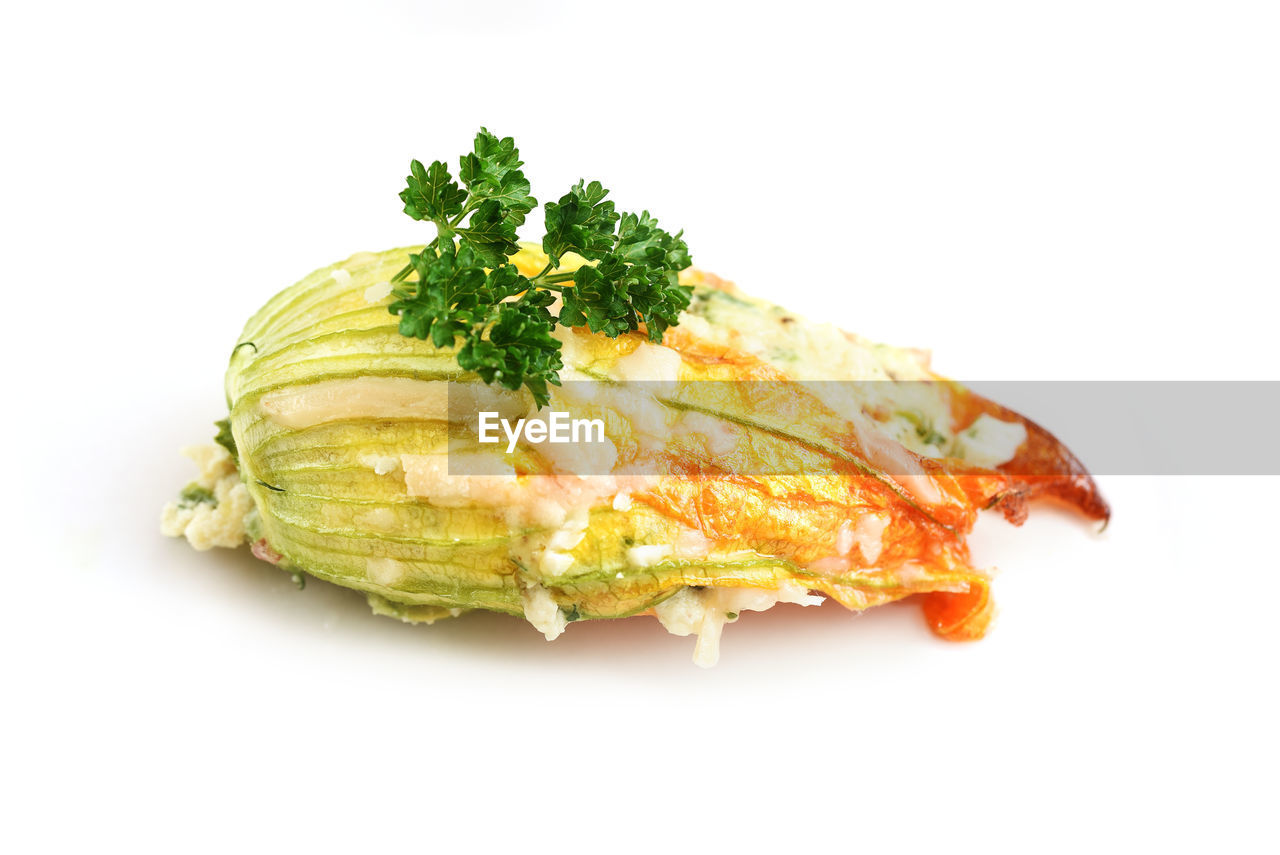 CLOSE-UP OF FISH ON PLATE AGAINST WHITE BACKGROUND