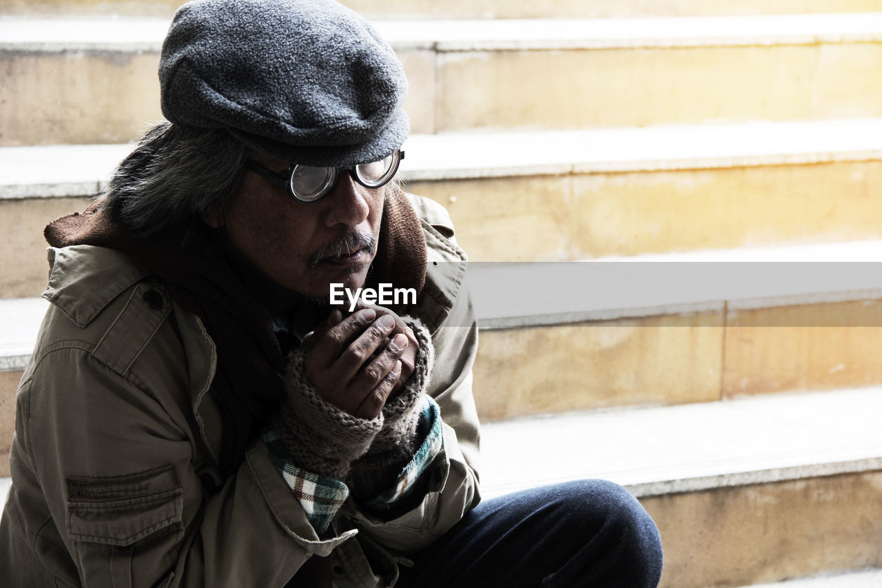 Beggar sitting on steps in city