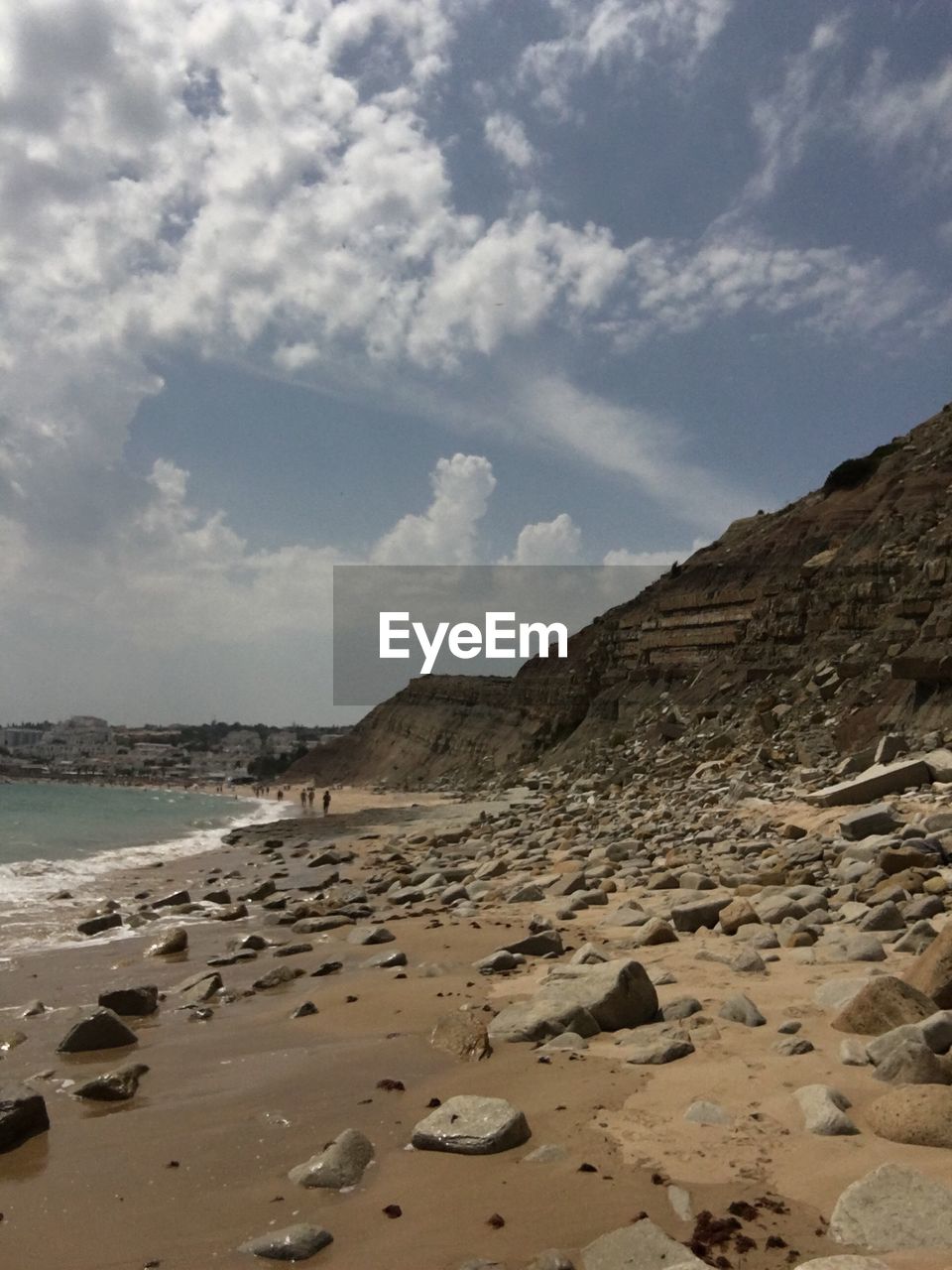 VIEW OF BEACH AGAINST CLOUDY SKY