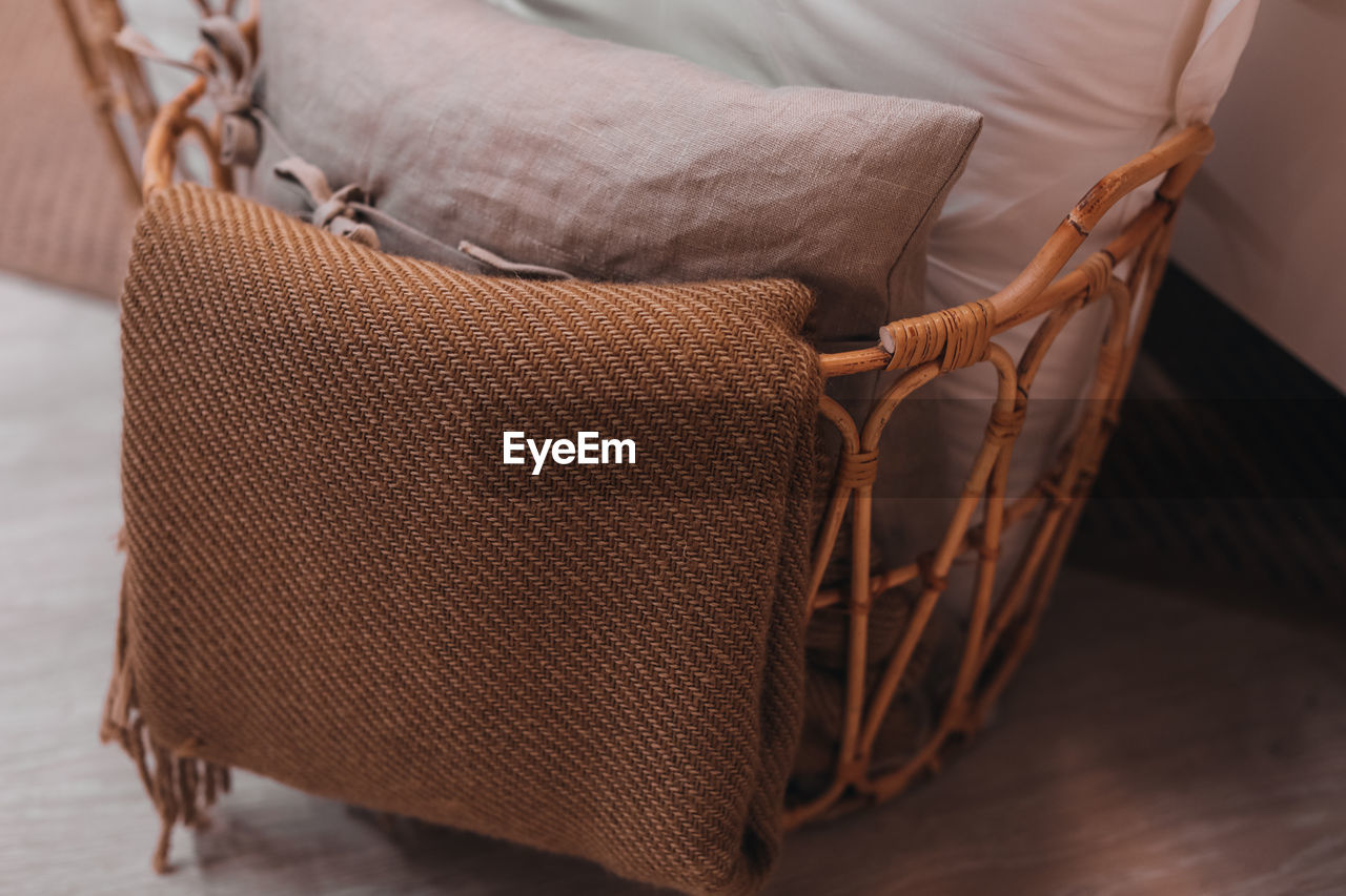 Beige fabrics in a wicker basket. cozy details in the home interior. autumn colors