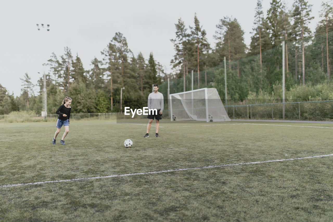 Father and daughter playing football