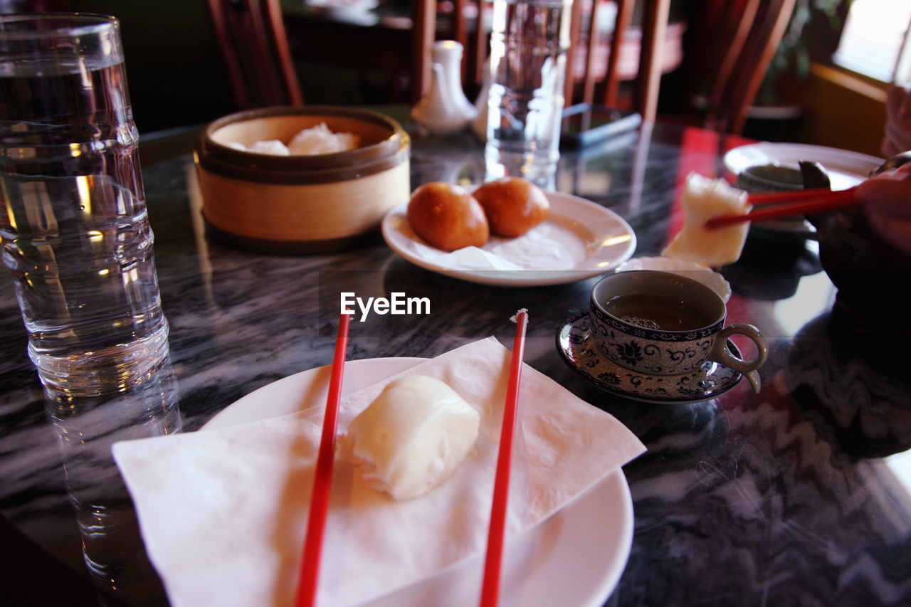 Close-up of fresh chinese dumplings with tea served on table in restaurant