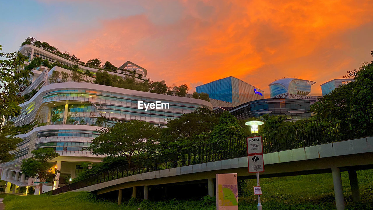 LOW ANGLE VIEW OF ILLUMINATED BUILDING AGAINST SKY DURING SUNSET