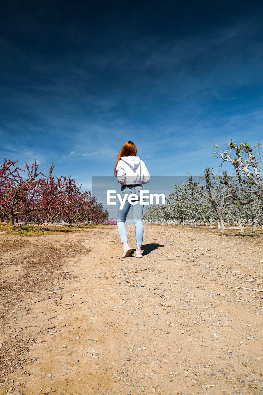 Woman standing on field against sky