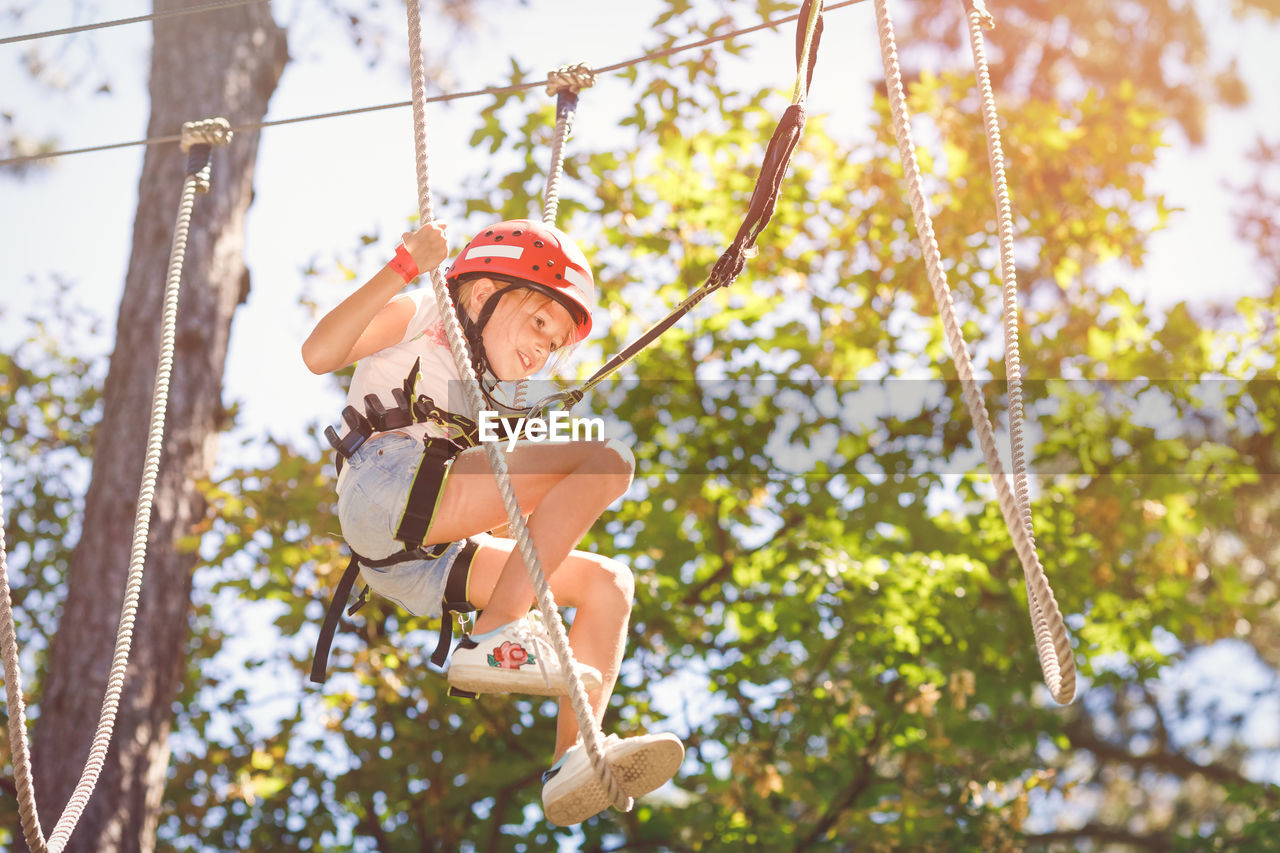 Happy girl hanging from tree