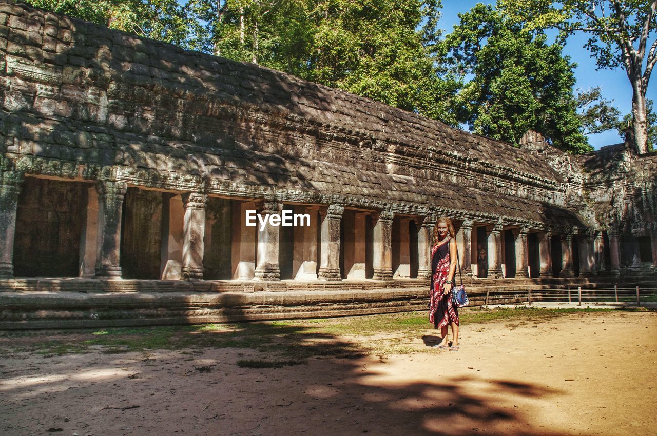 Woman in front of building in angkor wat. cambodia. 