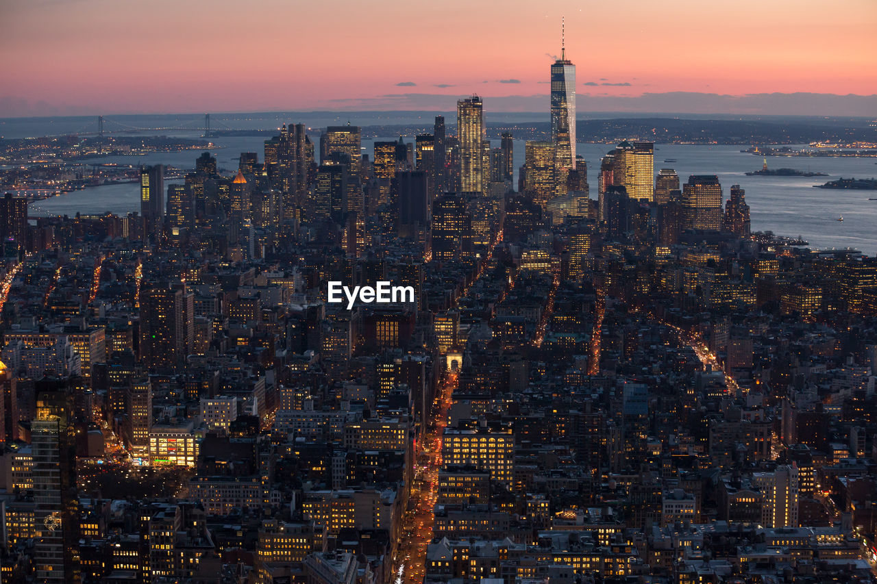 Aerial view of city lit up at sunset