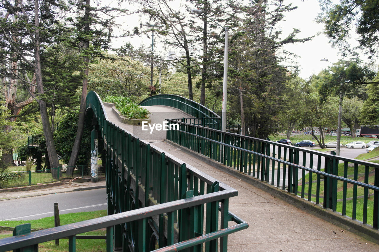 Footbridge in park against sky